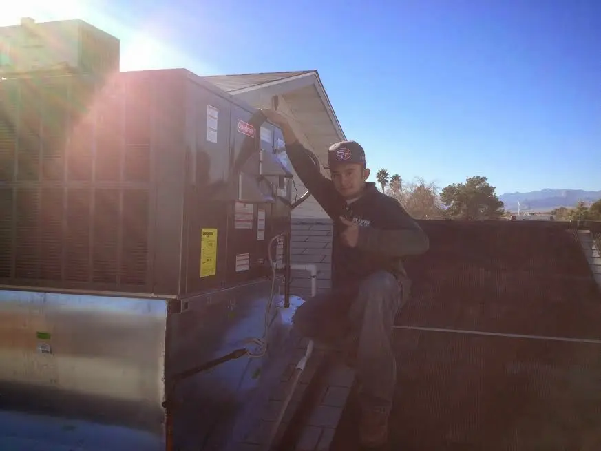 HVAC technician performing AC Tune-Up on a rooftop unit in Palos Heights